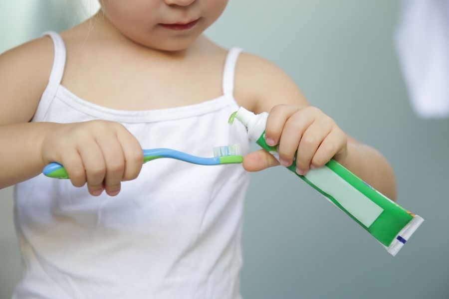 nakładanie pasty na szczoteczkę przez dziecko